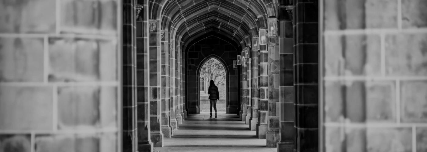 Student walking through campus of four year institution